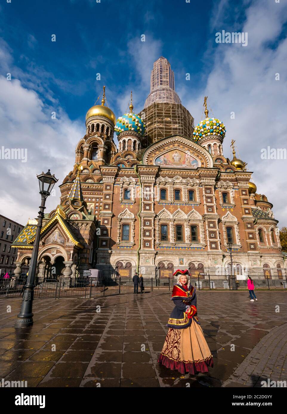 Turista en la Iglesia del Salvador en la sangre derramada fachada con mujer vestida con traje de época como atracción turística, San Petersburgo, Rusia Foto de stock