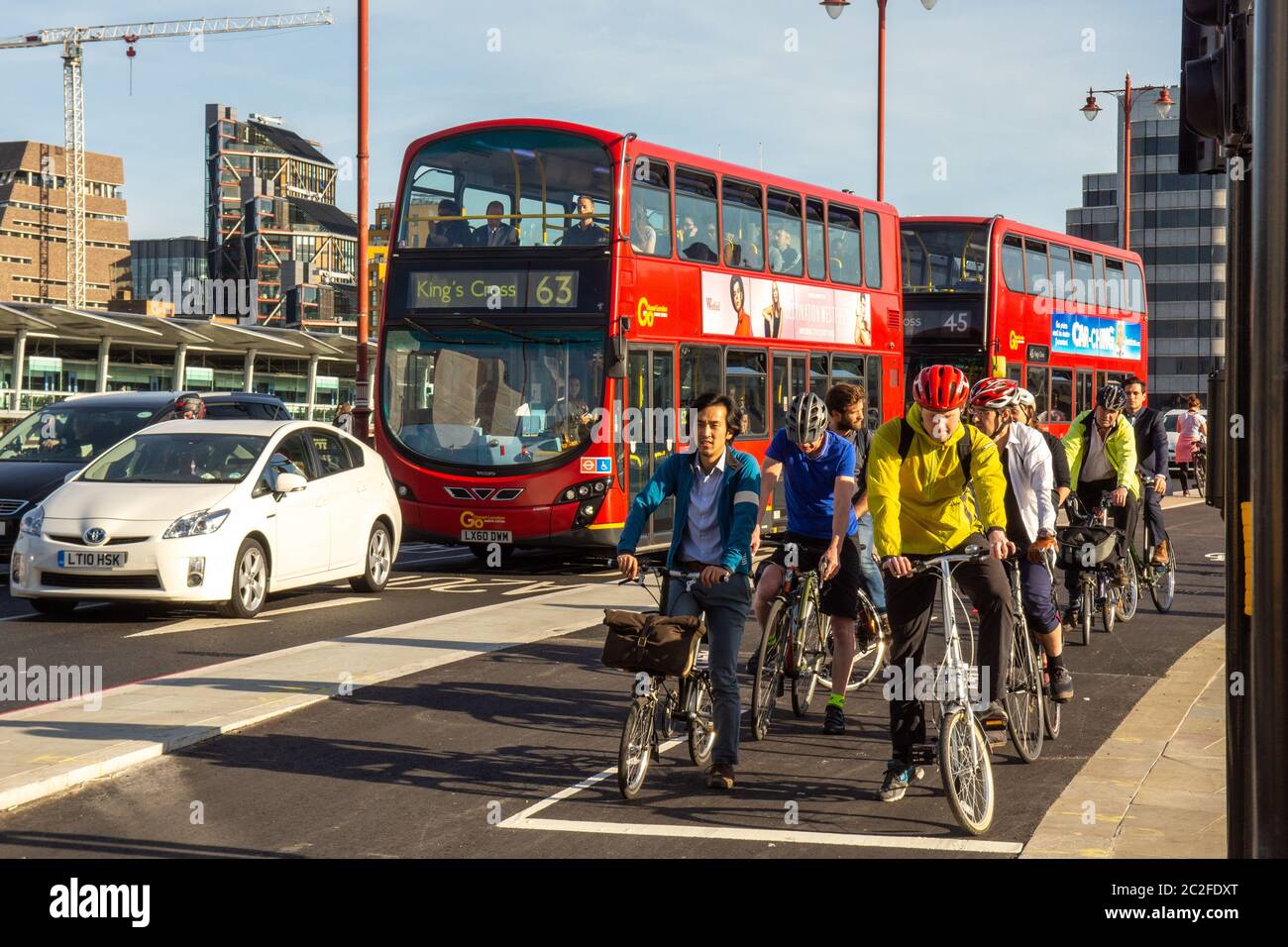 Londres, Inglaterra - 4 de mayo de 2016: Los ciclistsesperan en una señal de tráfico junto a los autobuses de dos pisos en la nueva autopista Cycle SuperHighway de Londres en el puente Blackfriars Foto de stock