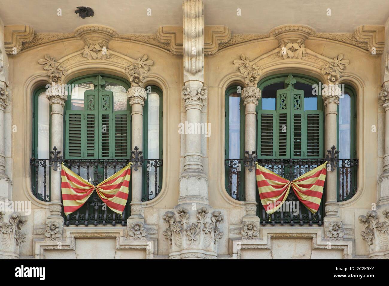 Banderas nacionales catalanas colocadas en los balcones franceses en los casos Ramos en Barcelona, Cataluña, España. El edificio diseñado por el arquitecto modernista catalán Jaume Torres i Grau fue construido entre 1906 y 1908 en la Plaza de Lesseps. Foto de stock