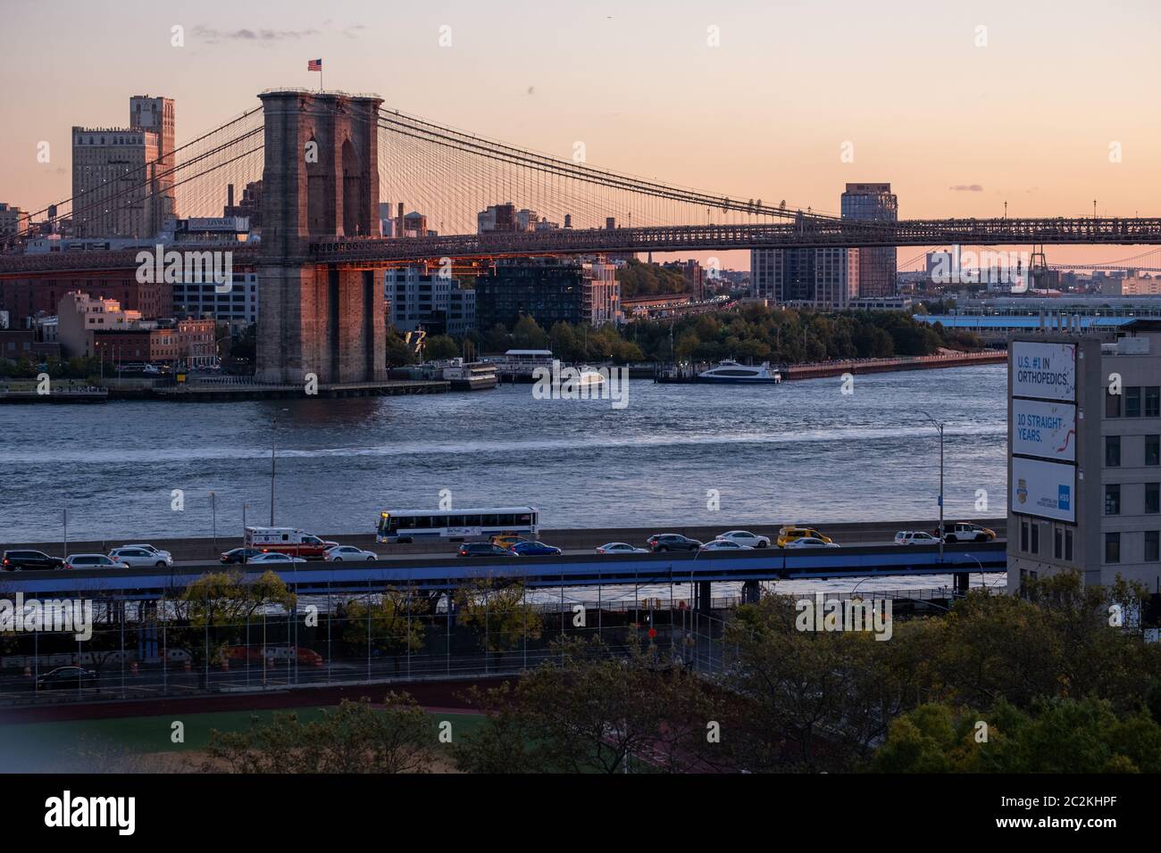 Luz cálida puesta de sol en la vista del Puente de Brooklyn desde el Puente de Manhattan Foto de stock