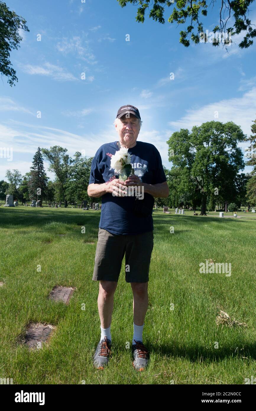 El infame fotógrafo Steve Skjold se encuentra en el lugar de la tumba de los padres con un ramo de peonías seleccionadas de su jardín. Minneapolis Minnesota Minnesota Minnesota, EE.UU Foto de stock