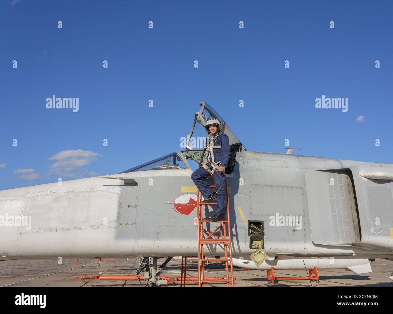 Piloto militar en el casco está cerca de avión Foto de stock