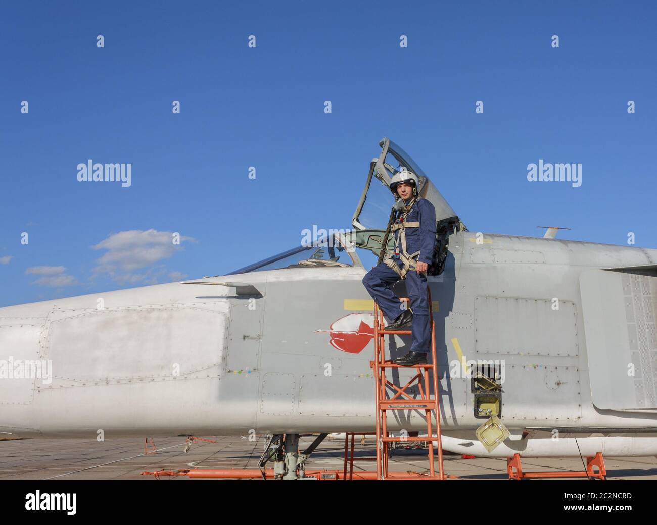 Piloto militar en el casco está cerca de avión Foto de stock