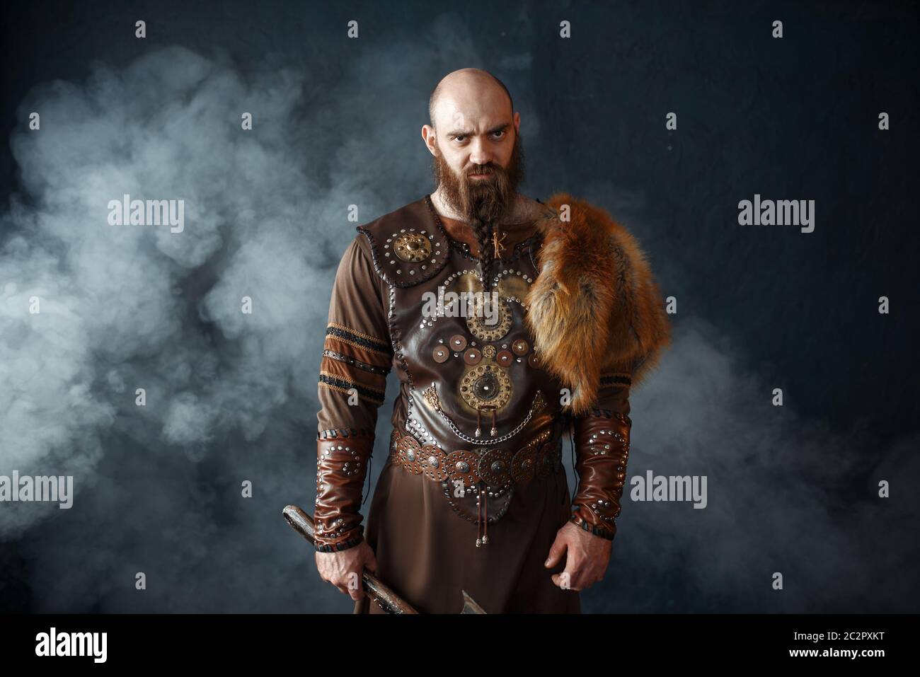 vikingo barbudo con hacha vestido con ropa nórdica tradicional, imagen  bárbara. Antiguo guerrero en humo sobre fondo oscuro Fotografía de stock -  Alamy