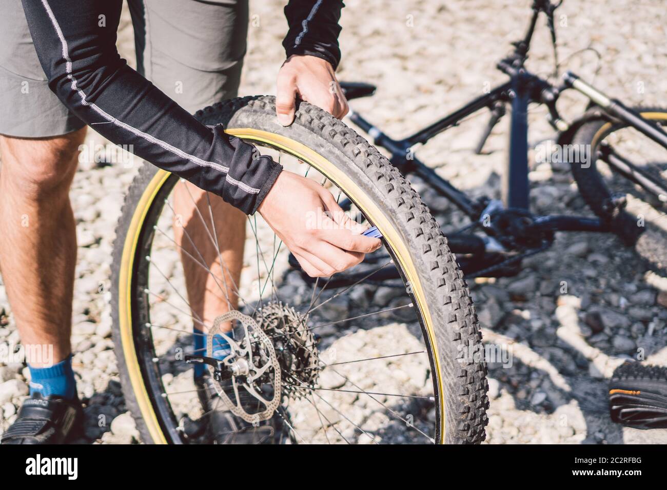 Que agradable Decano combate Reparación de bicicletas. Hombre reparando bicicleta de montaña. Hombre  ciclista en problemas rueda trasera caso de accidente. El hombre fija la  bicicleta cerca del lago en Fotografía de stock - Alamy