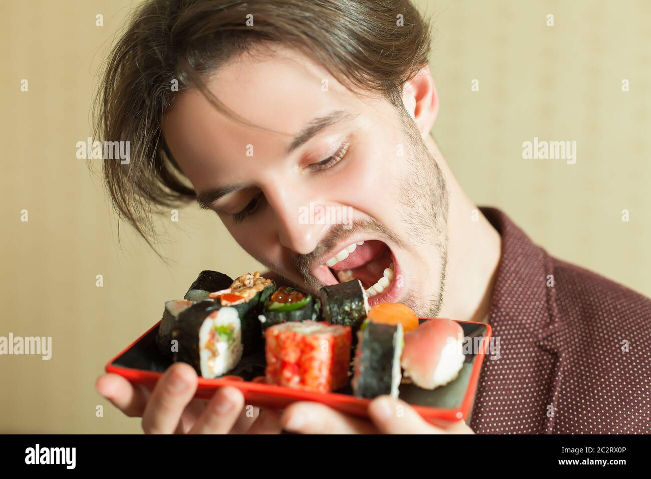 Insatisfactorio Fangoso Conquistador Un joven que intenta comer sushi sin las manos. Comida tradicional japonesa  Fotografía de stock - Alamy