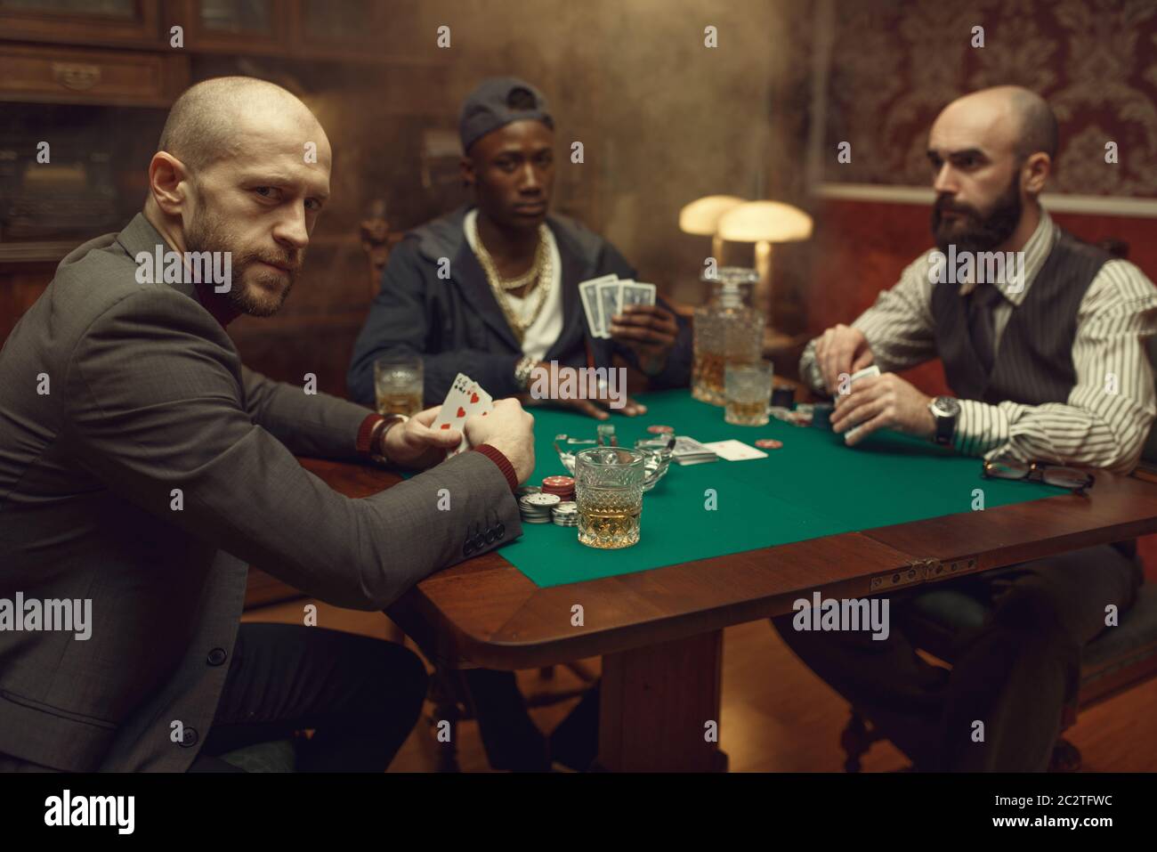 Jugadores de póker con cartas jugando en el casino. Juegos de azar  adicción, casa de juego. Los hombres se leisuan con whisky y puros  Fotografía de stock - Alamy