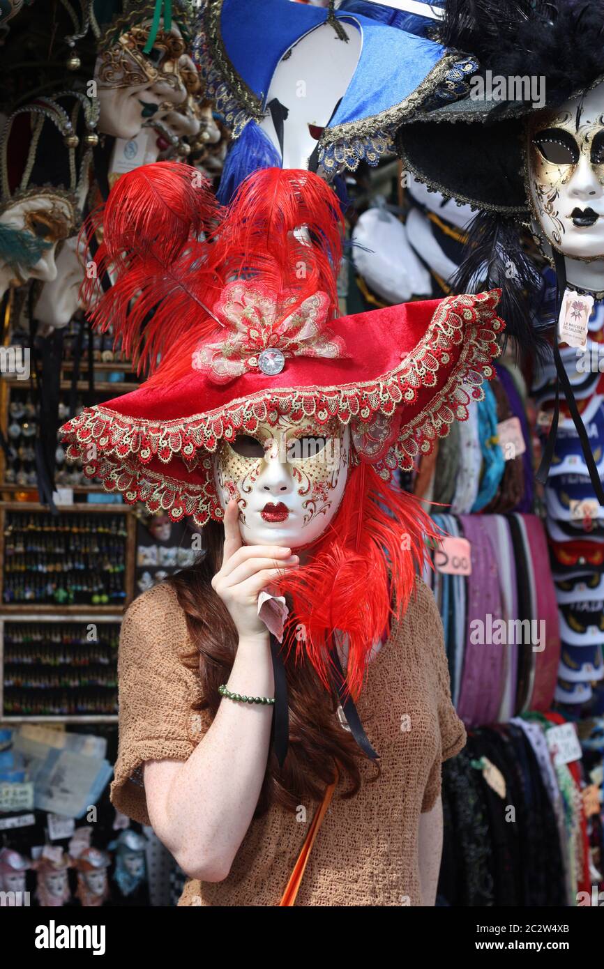 Chica que llevaba una máscara de Carnaval en el puesto de venta en Venecia Italia Foto de stock