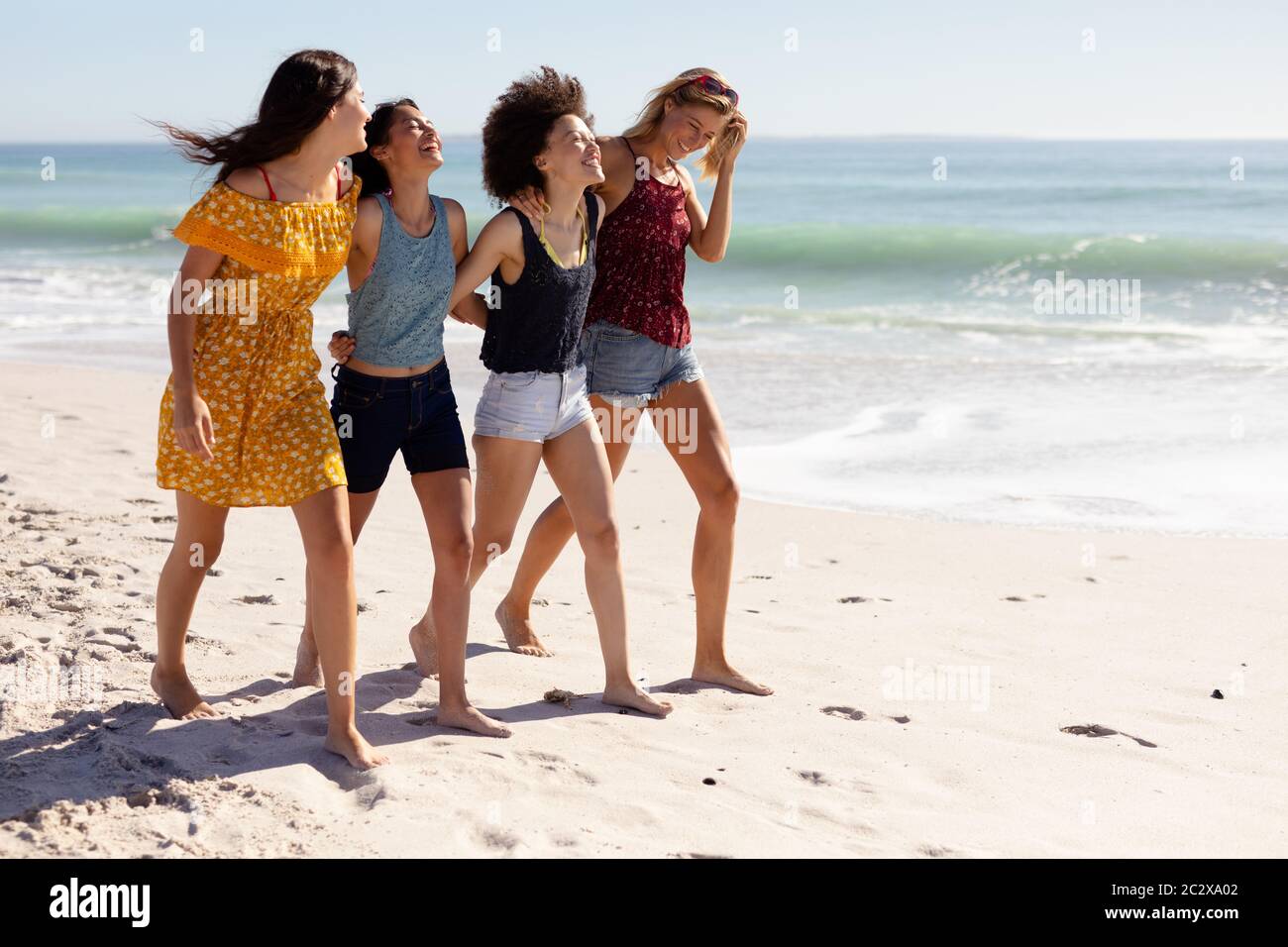 Grupo multiétnico de mujeres de pie en la playa Foto de stock