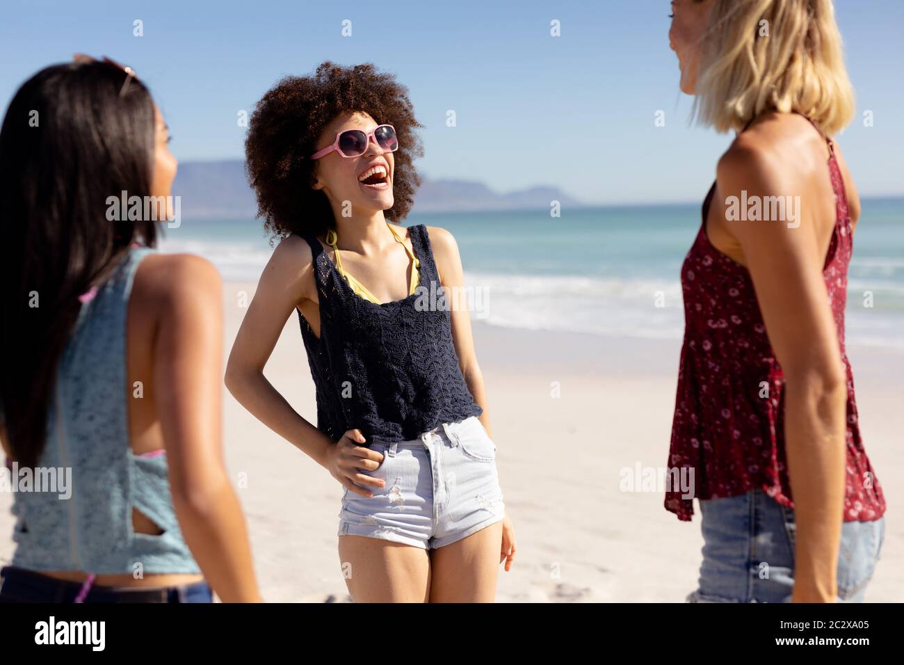 Grupo multiétnico de mujeres de pie en la playa Foto de stock