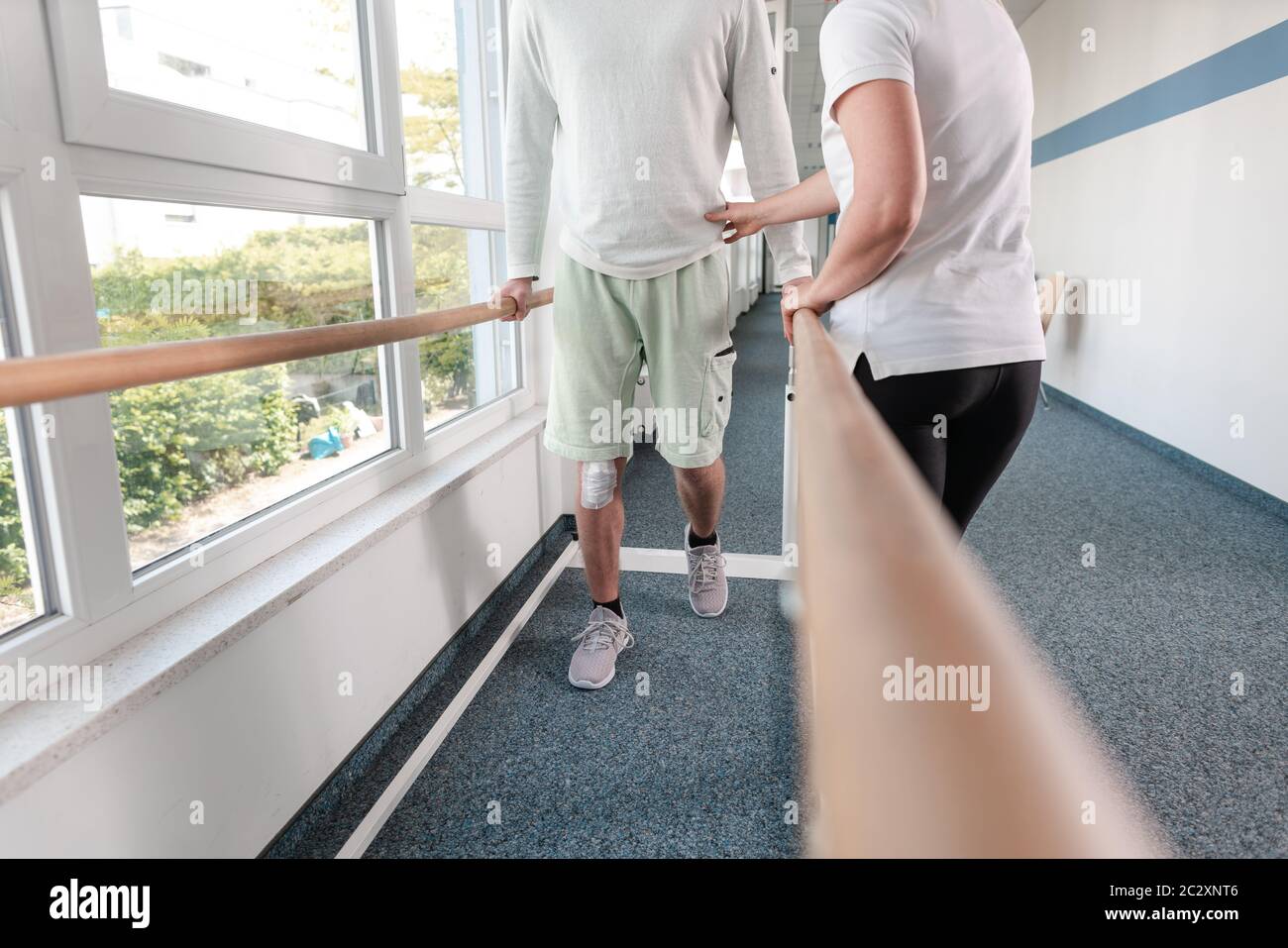 Fisioterapeuta masculino ayudando a una mujer mayor con muletas: fotografía  de stock © SimpleFoto #111765612