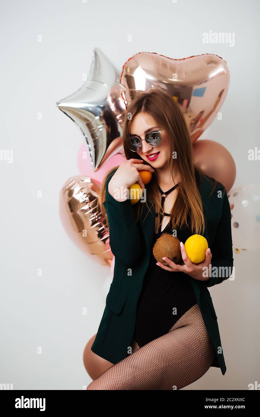 Sonriente feliz morena mujer de moda con globos posando. Disparo de estudio. Foto de stock