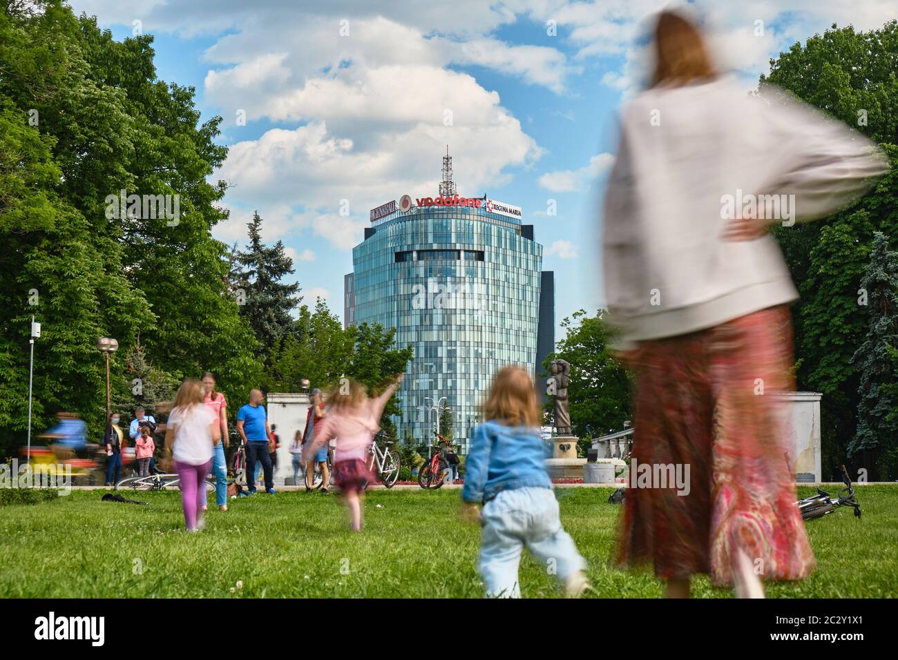 Bucarest, Rumanía - 1 de junio de 2020: Lapso de tiempo de la gente disfrutando de un día soleado en el parque Herastrau, sentado en el césped junto a las bicicletas, relajarse en el sm Foto de stock