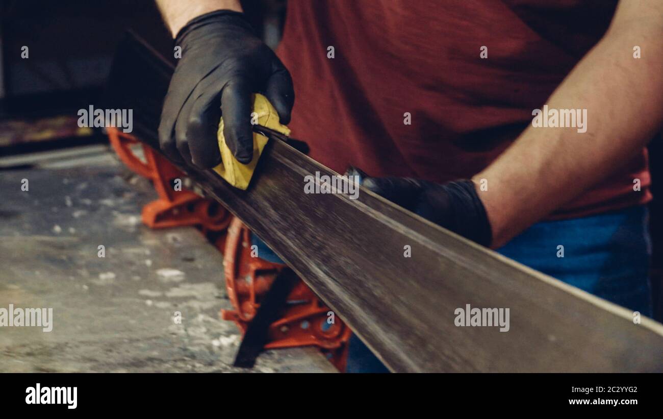 Hombre trabajador del taller de servicio de esquí haciendo afilado y  reparación de esquís. Afilar los bordes de las pistas con un ajuste manual  de bordes laterales también Fotografía de stock -