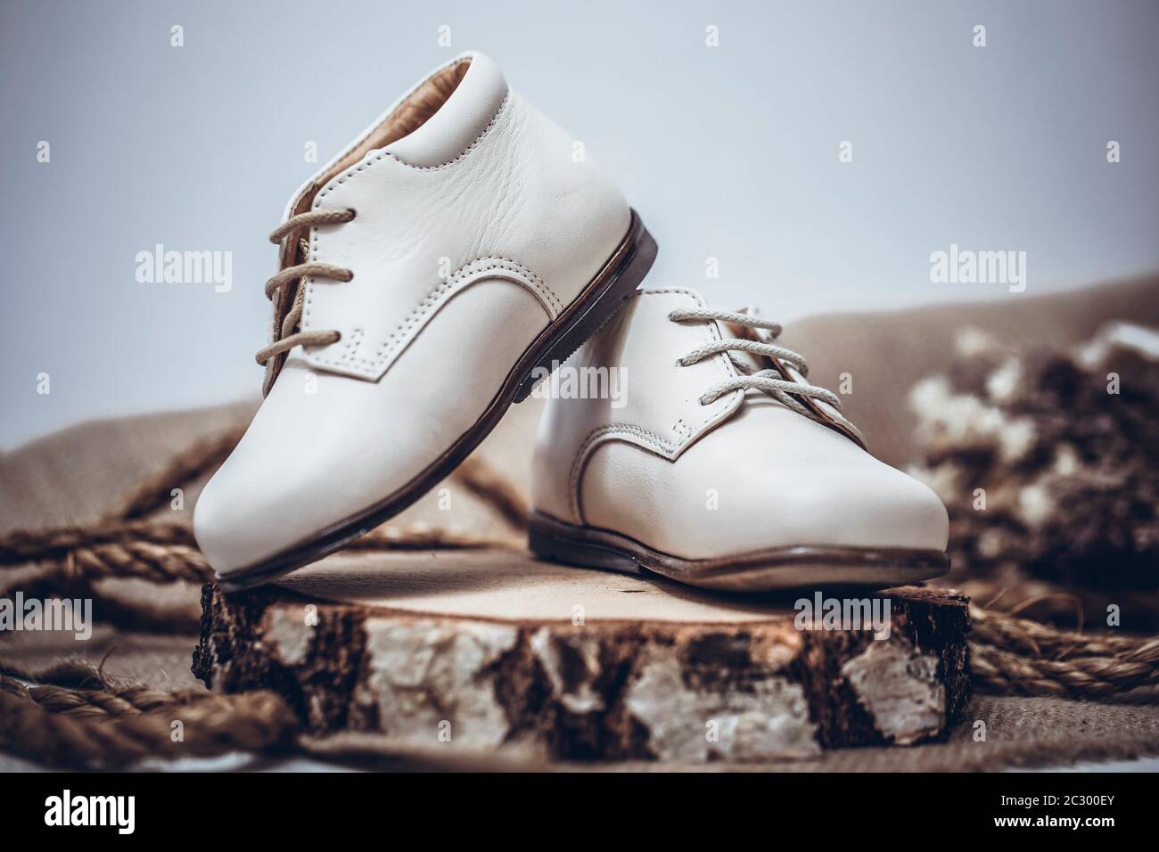 Imagen vintage de los zapatos para niños. Zapatos de cuero blanco para niños  sobre un viejo fondo de madera rústica Fotografía de stock - Alamy