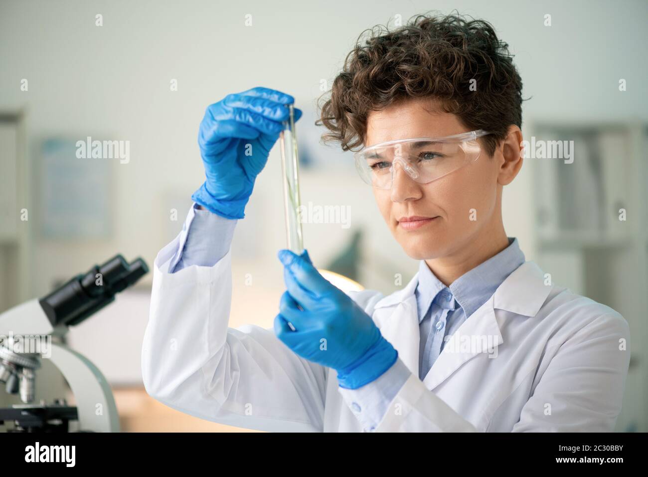 El científico con guantes de goma azules antes de experimentar en el  laboratorio.