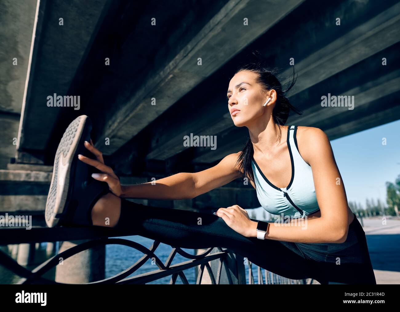Mujer deportiva corredor estirando las piernas para calentarse antes de hacer ejercicio Foto de stock