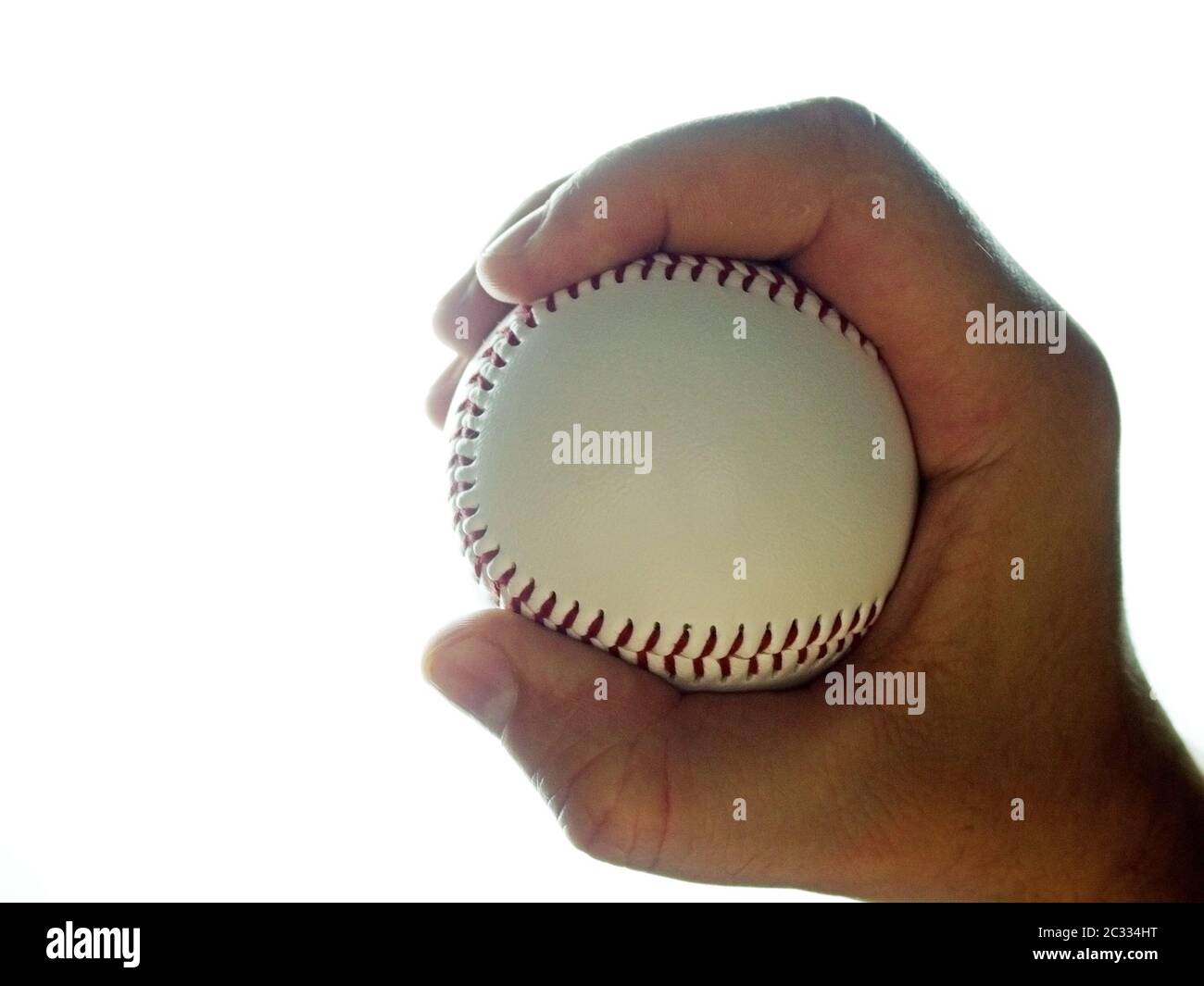 Pelota de béisbol en mano masculina sobre fondo blanco Foto de stock