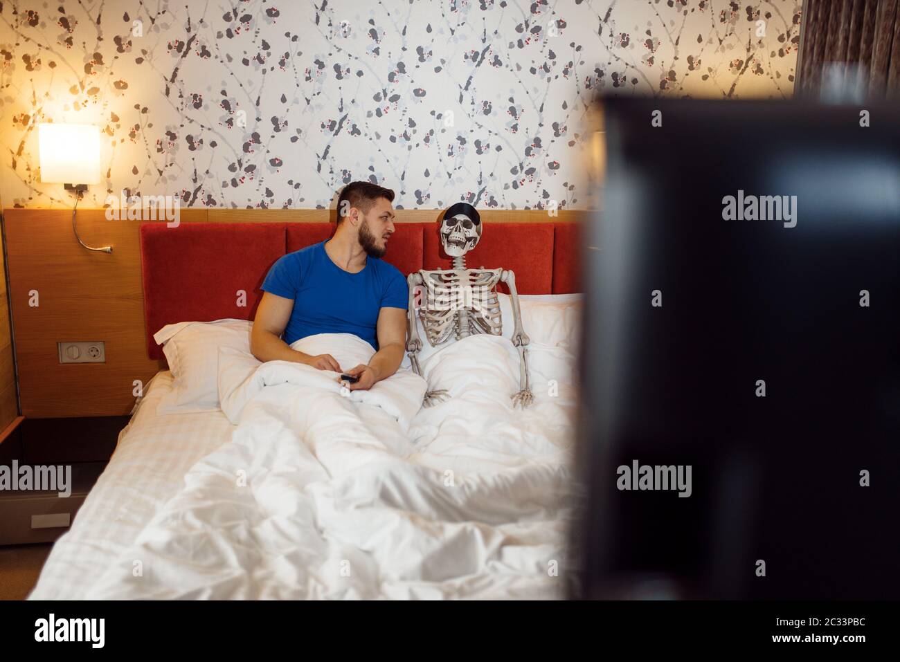 Hombre y esqueleto humano viendo la televisión en la cama, mala relación.  Pareja que tiene problemas, conflicto familiar o conflicto Fotografía de  stock - Alamy