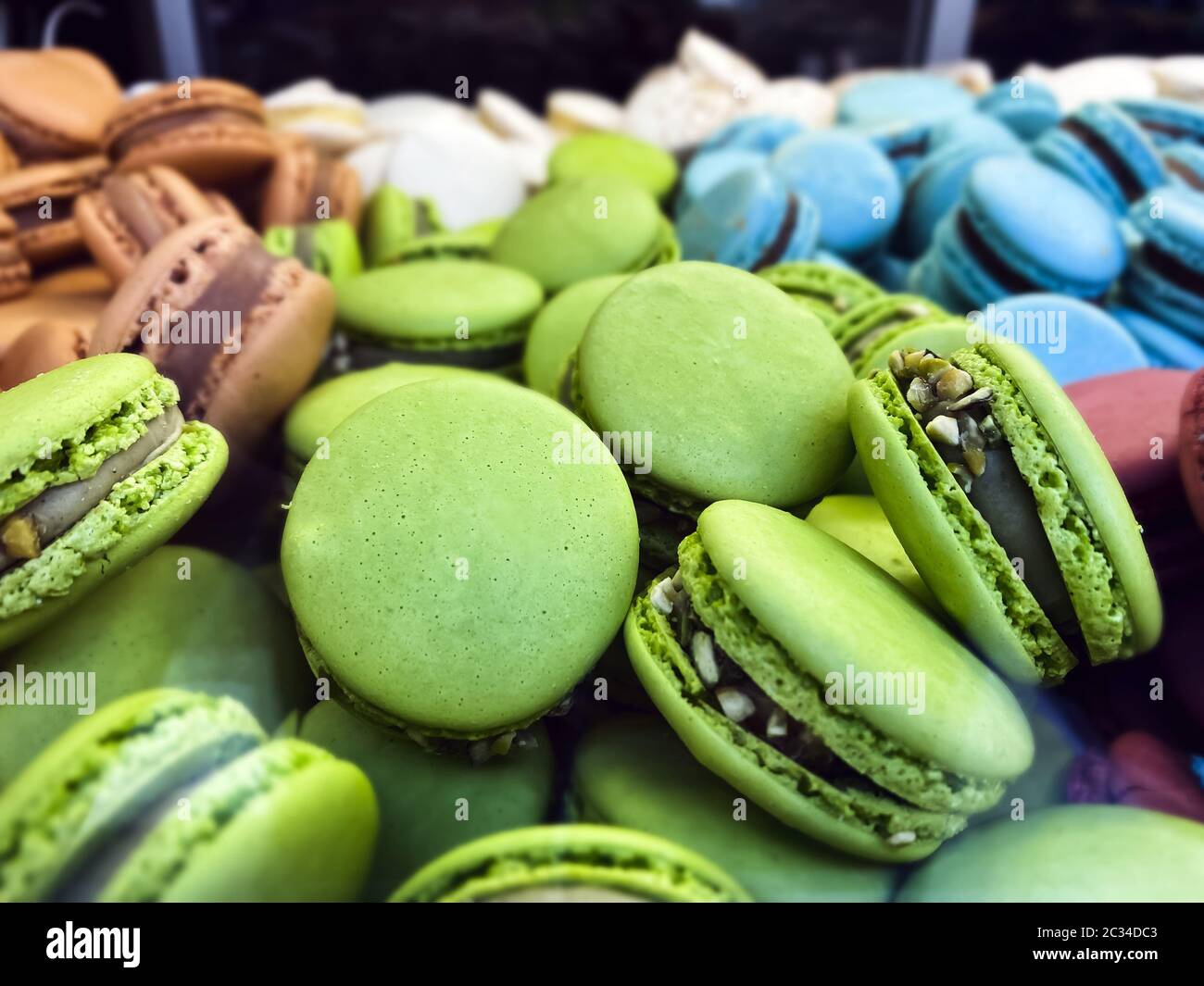 muchas galletas macarons coloridas arregladas desordenadamente Foto de stock