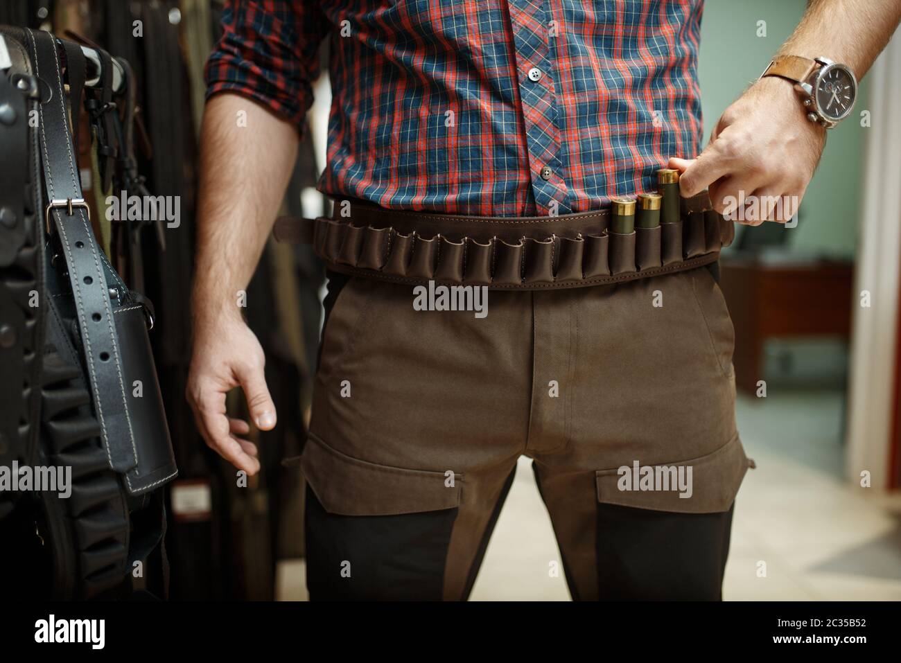 Hombre escogiendo cinturón de munición y uniforme para la caza en tienda de  armas. Euqrepo para cazadores en stand en tienda de armas, deporte tiro  hobby Fotografía de stock - Alamy