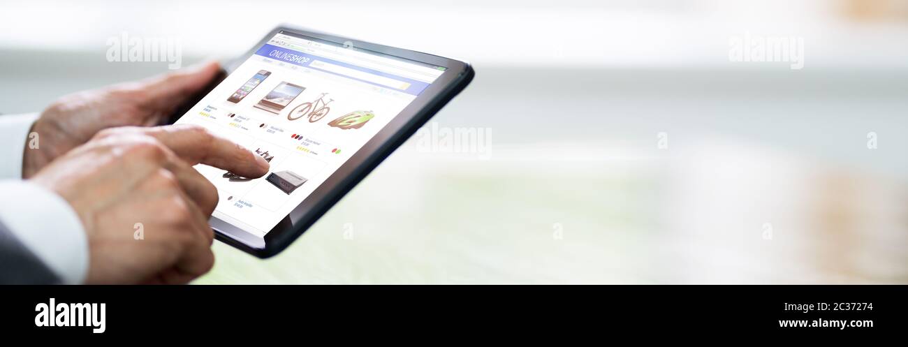 Mano de la mano de la compra de tabletas en línea en el sitio web de comercio electrónico Foto de stock