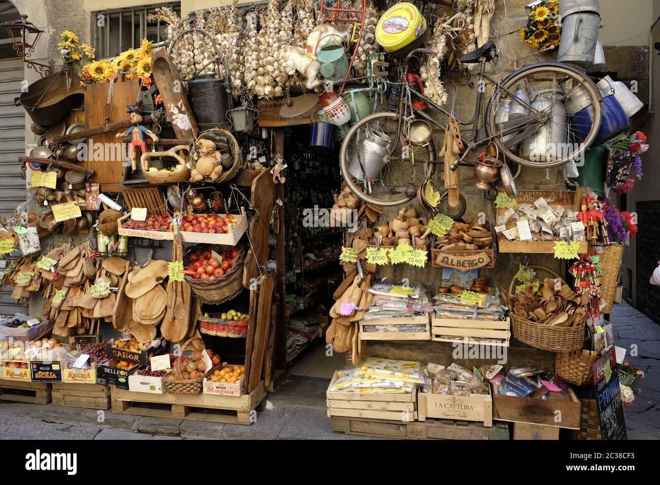 Tienda con mucho carácter que muestra frutas, verduras y artesanías en una calle lateral de Florencia cerca del Arno. Foto de stock