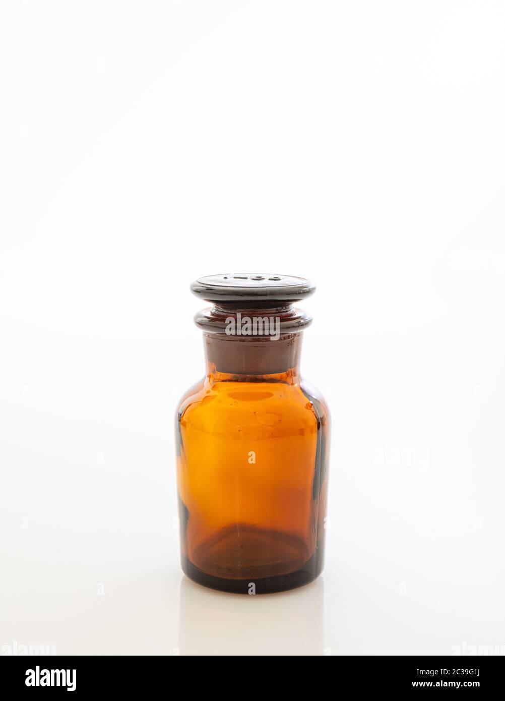 Marrón medicamentos botella de vidrio, transparente, vacío aislado contra fondo blanco, vertical, espacio de copia Foto de stock