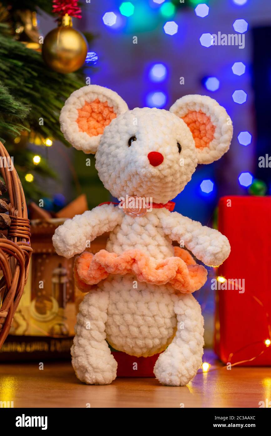 Tejido blanco en un ratón de juguete sunface bajo un árbol de Navidad Foto de stock