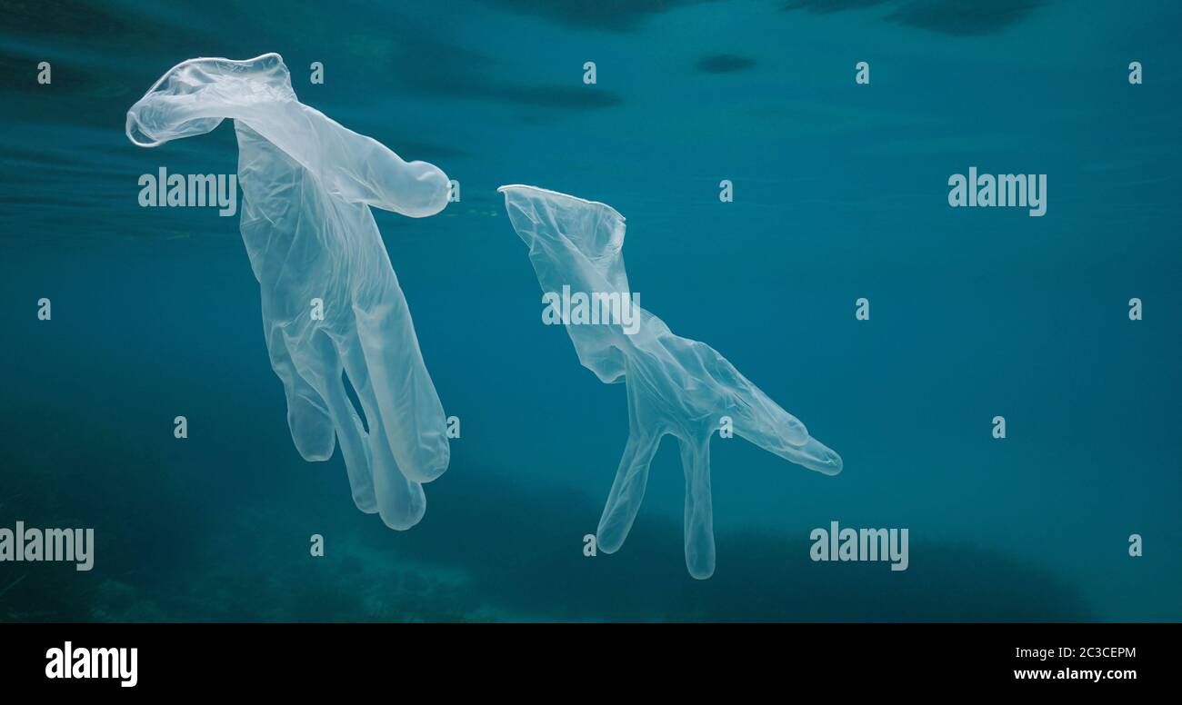 Guantes transparentes desechables bajo el agua, residuos plásticos en el mar desde coronavirus COVID-19 pandemia Foto de stock