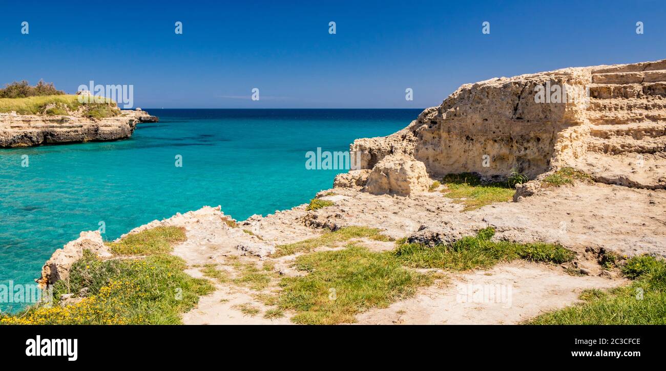 El importante sitio arqueológico y turística de Roca Vecchia, en Puglia, Salento, Italia. Mar turquesa, cielo azul, rocas, sol, vegetación exuberante Foto de stock