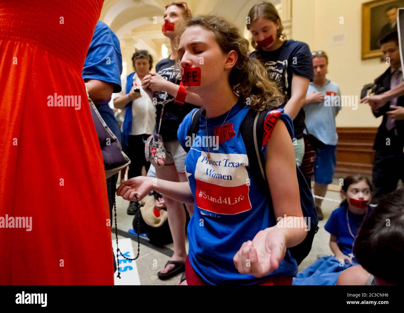 11 de julio de 2013 Austin, Texas EE.UU.: La joven oponente del aborto femenino ora durante un rally pro-vida en el Capitolio de Texas. Cientos de partidarios pro-vida y pro-elección se llenaron en el edificio mientras los senadores estatales debatieron sobre HB2, una ley controvertida que impone restricciones más estrictas al acceso de las mujeres a los abortos. El proyecto de ley se aprobó con un voto de 19-11, con los 18 republicanos y 1 demócrata votando sí. ©MCK/Bob Daemmrich Photography, Inc Foto de stock
