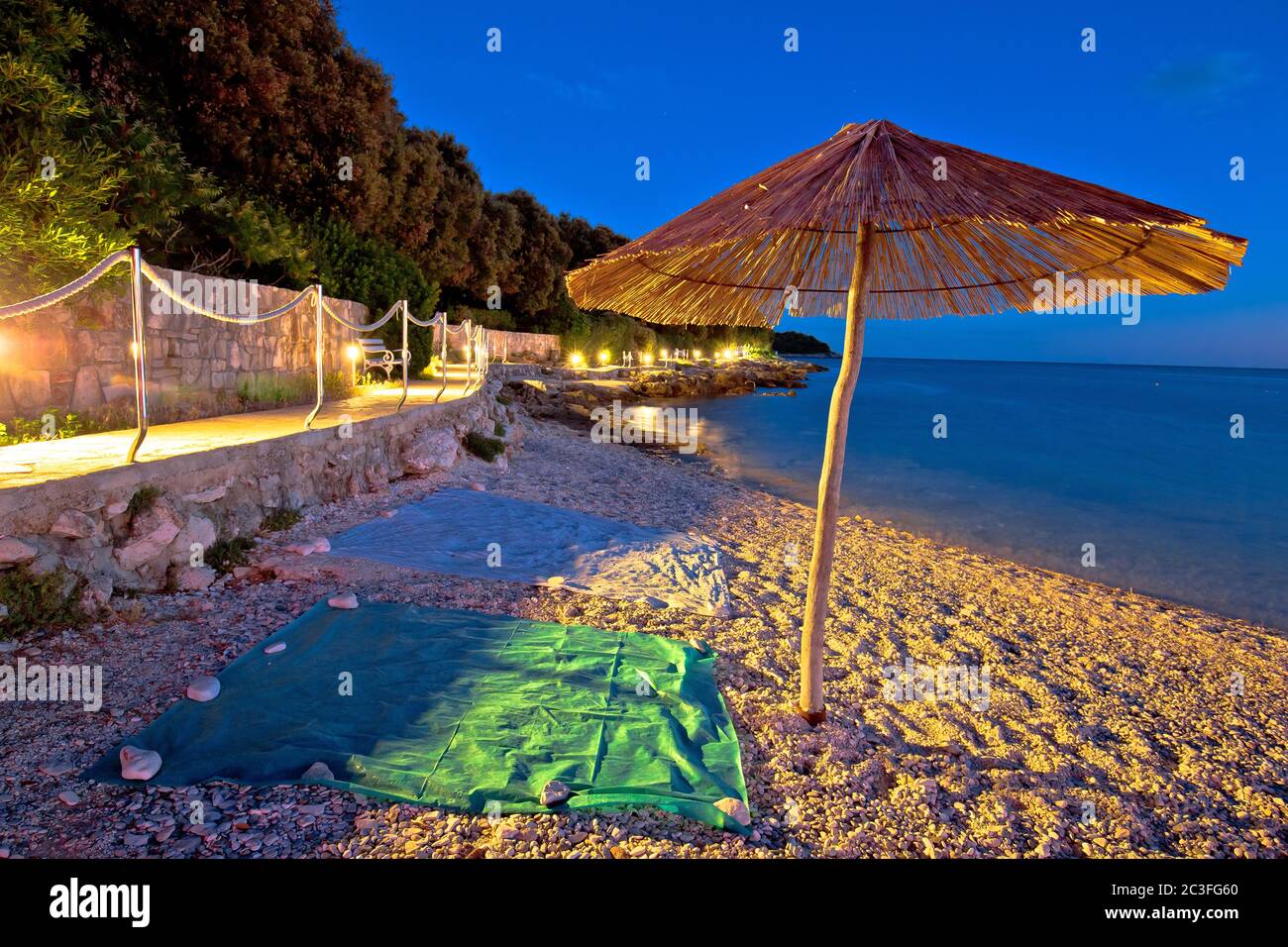 Playa y sombrilla en la vista de noche, mar Adriático Foto de stock