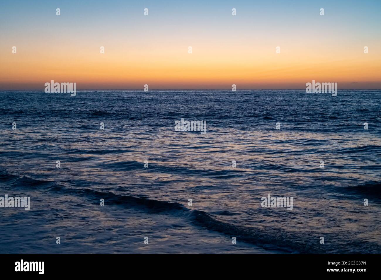Colorido amanecer sobre el profundo mar azul Foto de stock