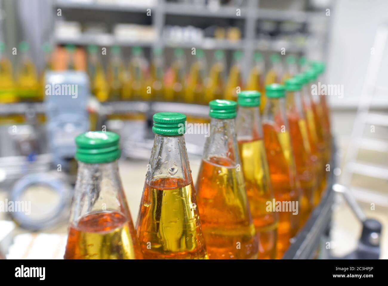 jugo de manzana en botellas de vidrio en una fábrica para la industria alimentaria - embotellado y transporte Foto de stock
