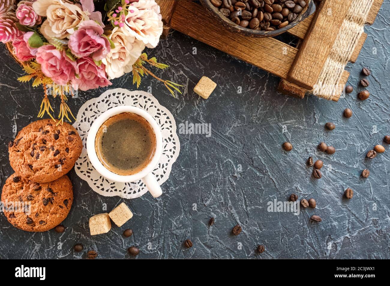 desayuno en estilo vintage. Una taza de café con trozos de azúcar de caña,  galletas con chocolate y un jarrón con granos de café. Vista superior  Fotografía de stock - Alamy