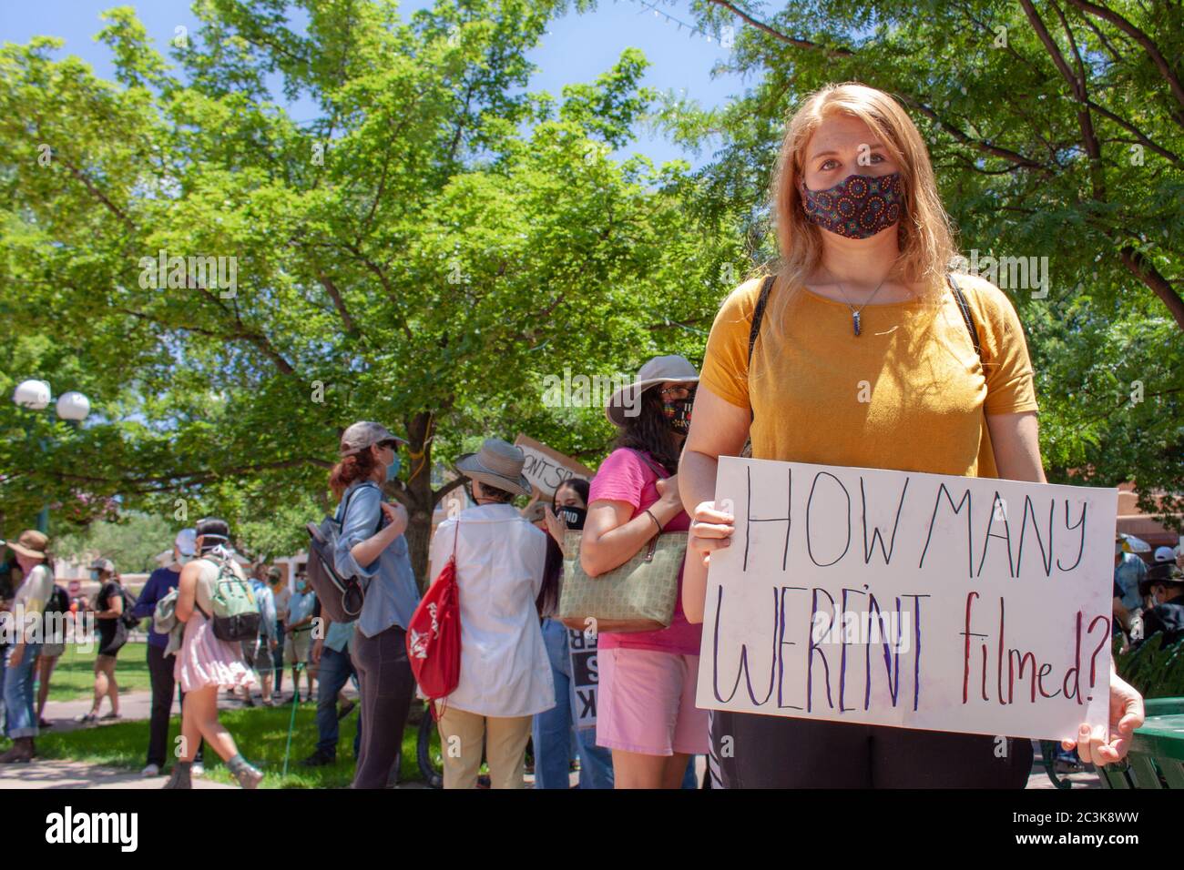 Una joven mujer blanca sostiene la señal que dice "¿Cuántos no fueron filmados?" En una protesta de Black Lives en Santa Fe, Nuevo México, EE.UU Foto de stock