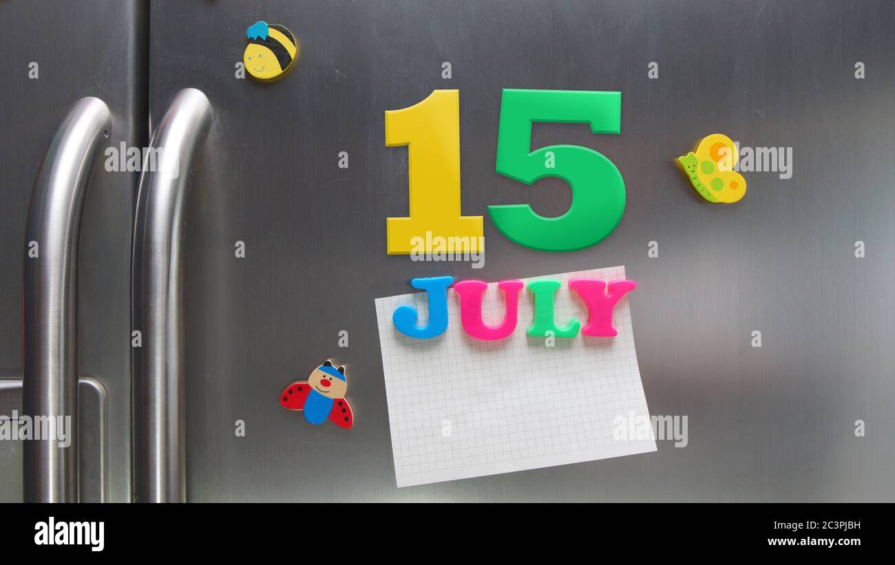 Julio 15 fecha calendario hecha con letras magnéticas de plástico que contienen una nota de papel gráfico en la puerta del refrigerador Foto de stock