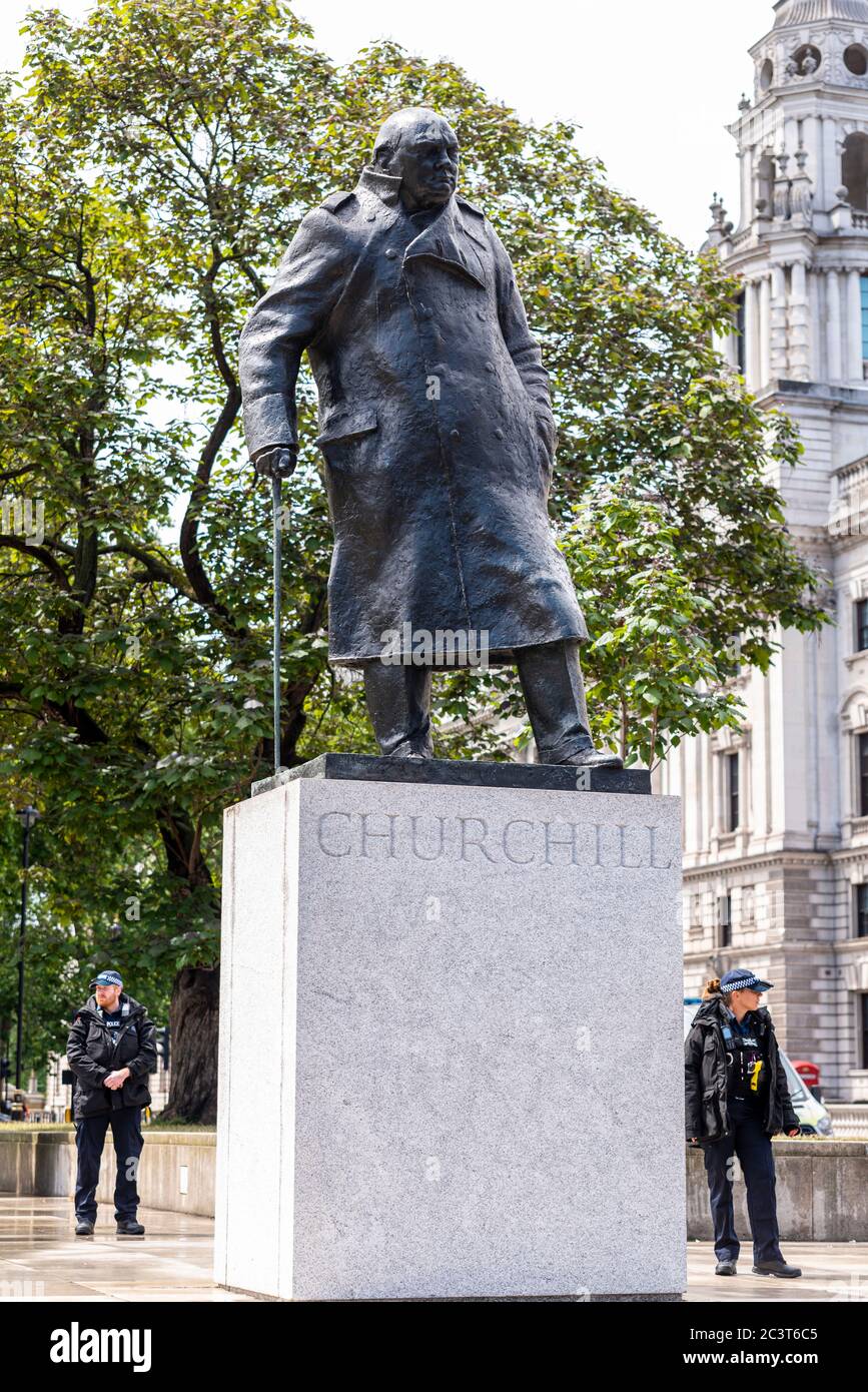 La estatua de Winston Churchill en las afueras del Palacio de Westminster ha sido descubierta tras el vandalismo de los manifestantes de Black Lives Matter. Los agentes de policía vigilan Foto de stock