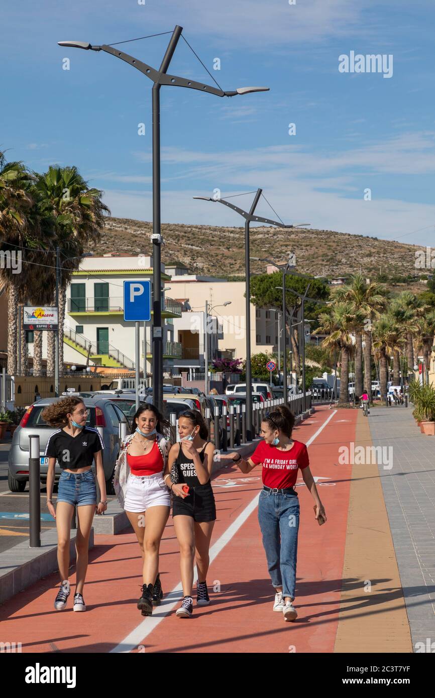 Adolescentes caminando juntos a lo largo de la costa Porto Empedocle, Agrigento, Sicilia Foto de stock
