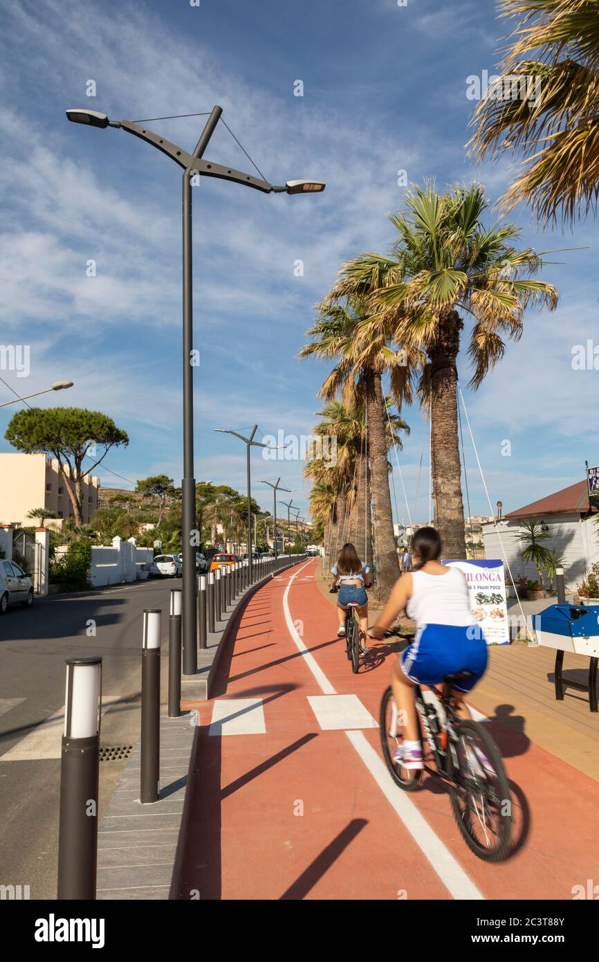 Paseo en bicicleta a lo largo del paseo marítimo de Porto Empedocle, Agrigento, Sicilia Foto de stock