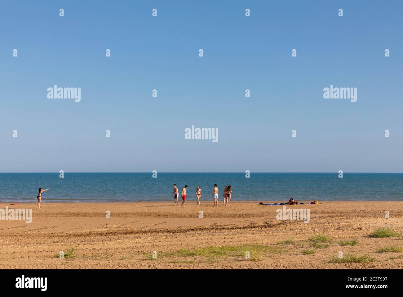 Grupo de amigos jugando al juego de pelota en la playa de Porto Empedocle, Agrigento, Sicilia, Italia Foto de stock