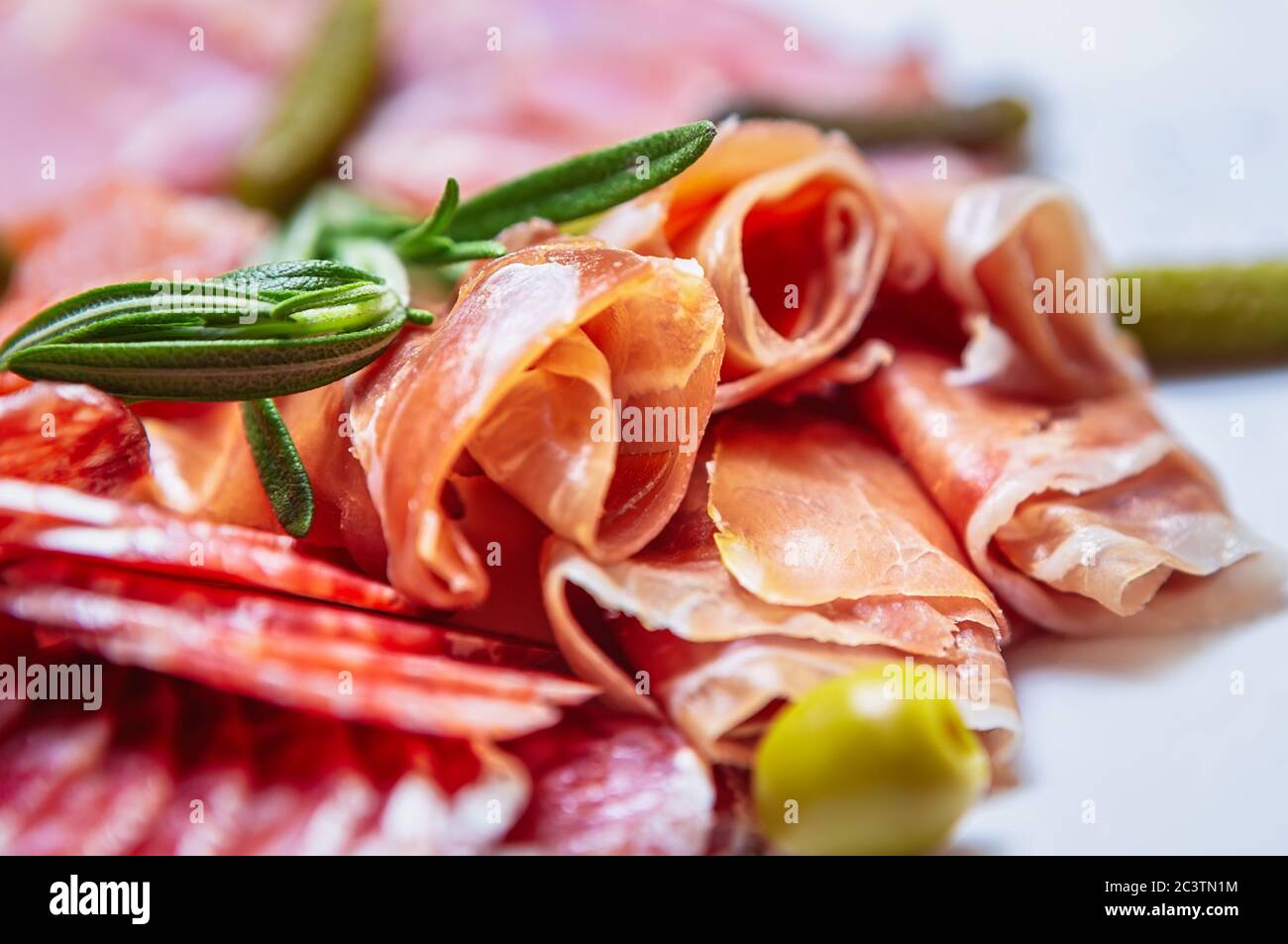 Deliciosos aperitivos de carne para la cena. Jamón español en rebanadas, salchichas de pepperoni, jamón de ternera servido en el plato del restaurante para aperitivos. Gourmet comida mediterránea f Foto de stock