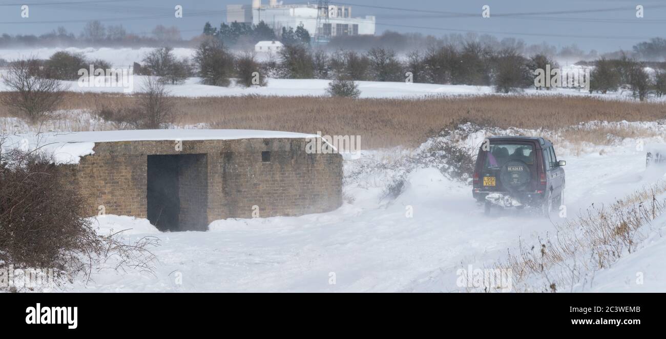 En Hoo medway un Land Rover, conduce a través de un camino de pie, entre el dique y GHQ Bunker. Durante una tormenta mientras Emma batea al Reino Unido Foto de stock