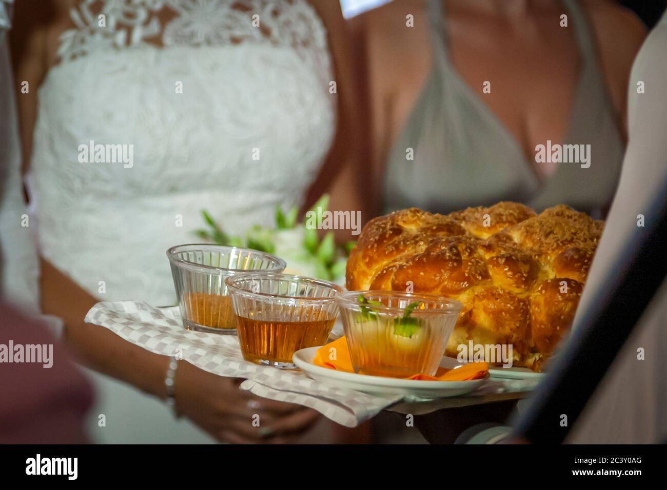 Boda en Bulgaria. Al principio de la celebración de la boda de la noche, cada huésped recibe de la novia y el novio un pedazo de pan rociado con miel y una especia salada Foto de stock