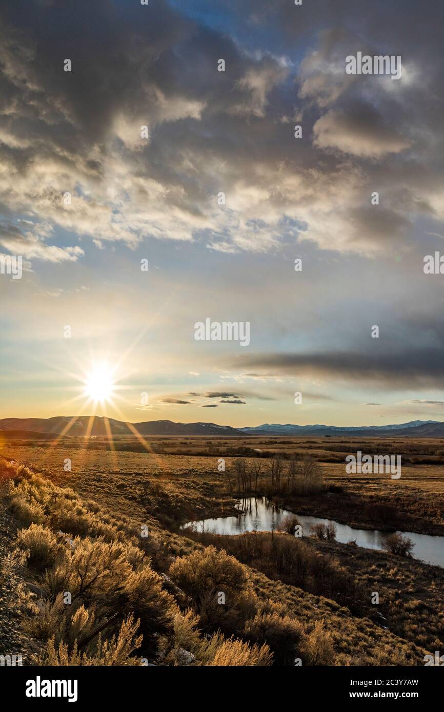 Estados Unidos, Idaho, Picabo, puesta de sol sobre la llanura y la cadena montañosa Foto de stock