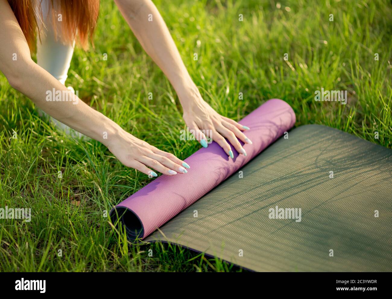 Mujer foll up mat después de yoga entrenamiento de cerca en el parque vida  saludable Fotografía de stock - Alamy