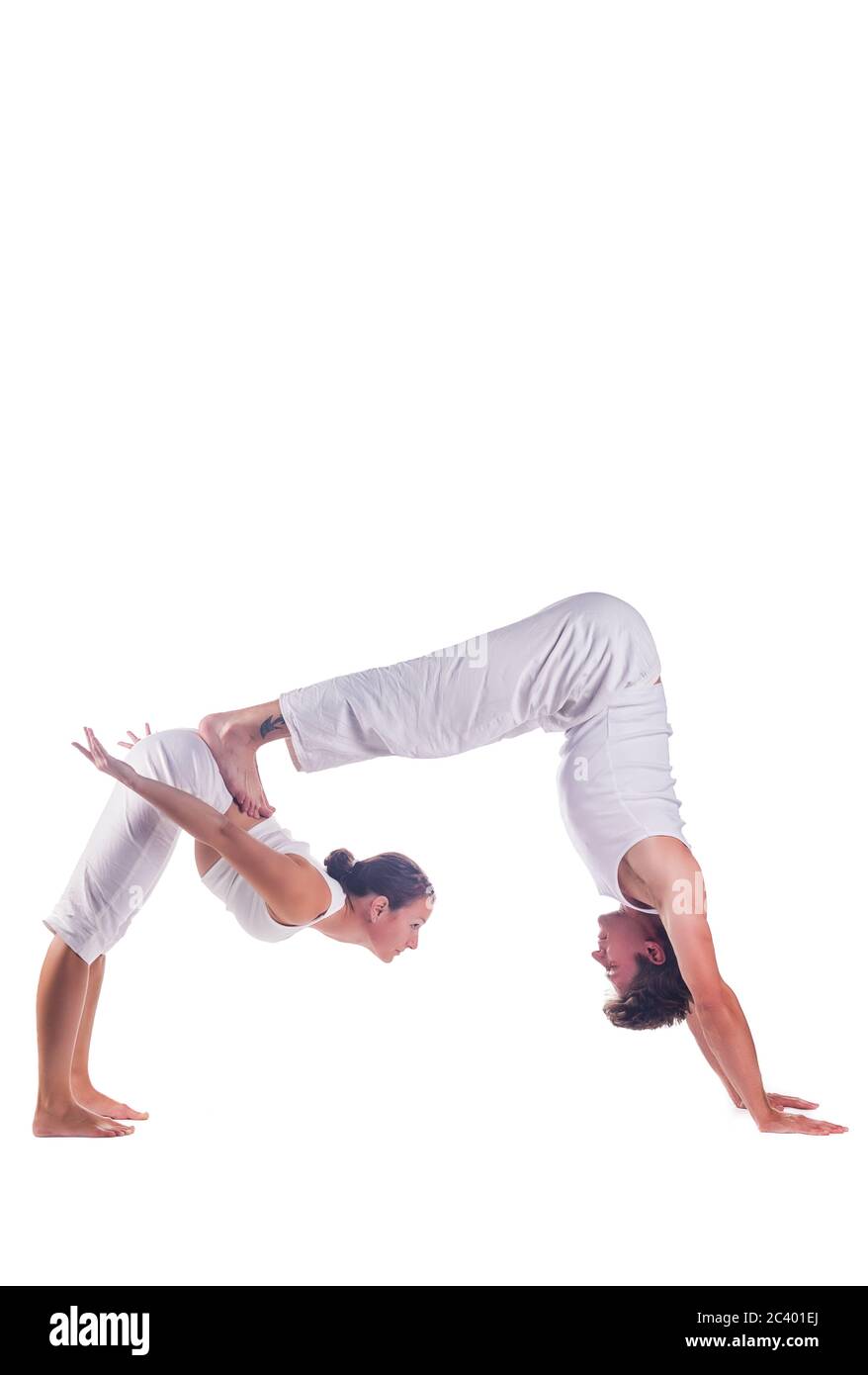 Pareja practicando yoga acro contra fondo blanco Foto de stock