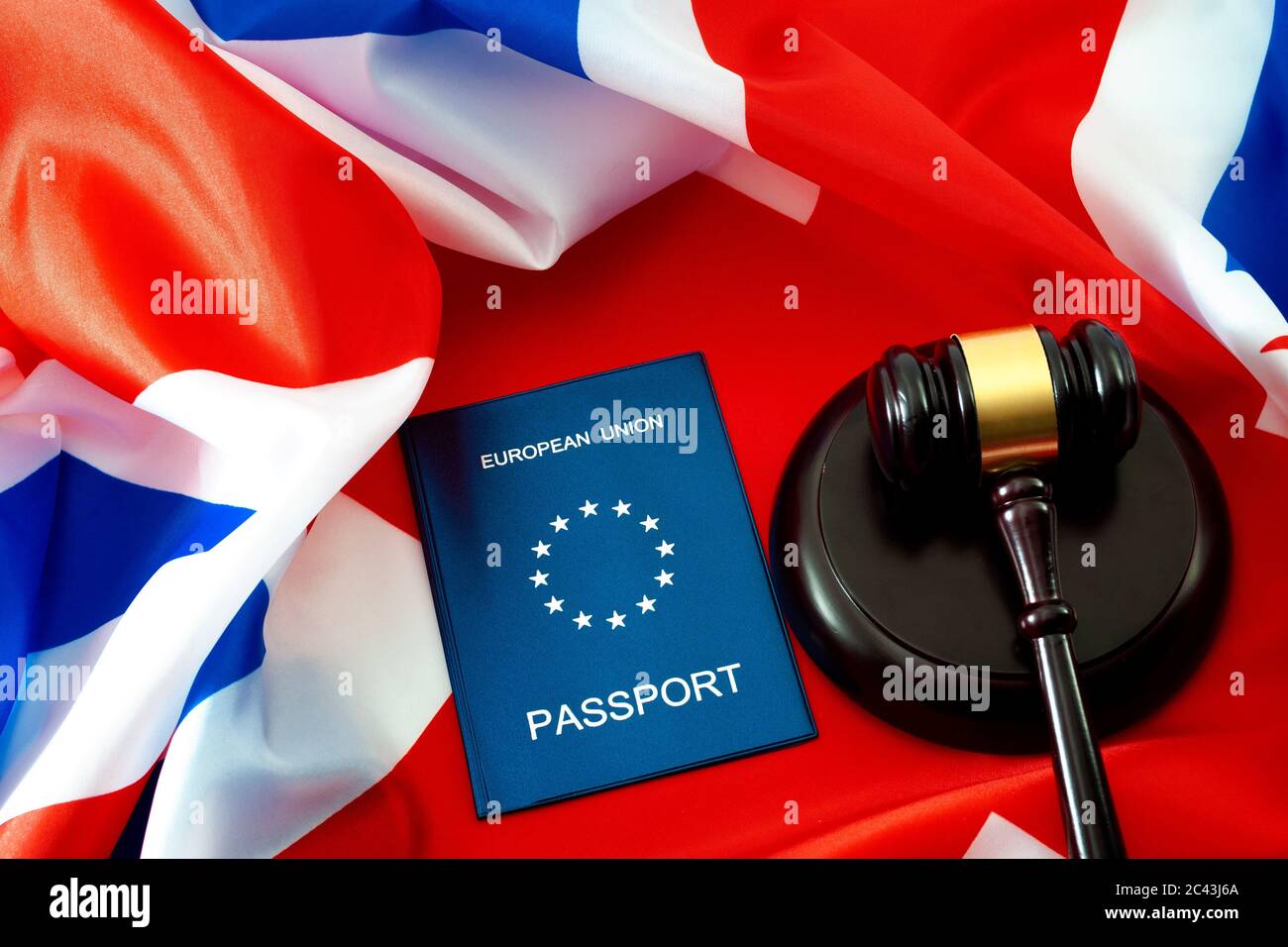 La ley de inmigración, el Brexit y los derechos de los ciudadanos de la Unión Europea en Gran Bretaña tema conceptual con pasaporte de la UE y una gavila de madera contra la bandera del Reino Unido también conocido Foto de stock