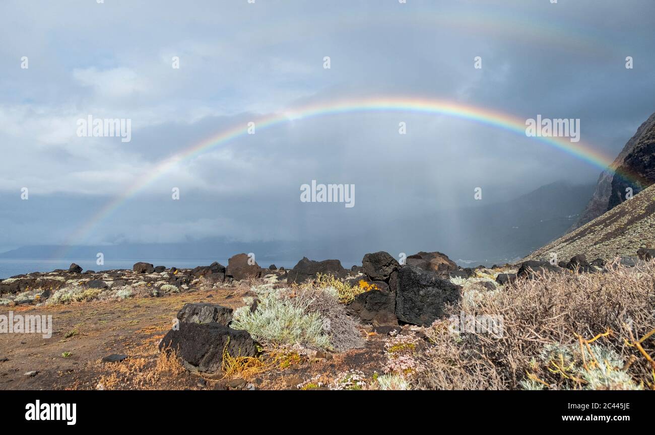 España, el Hierro, Doble arco iris sobre la zona costera rocosa Foto de stock